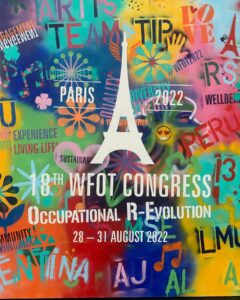 Eine Fotografie einer Wand, auf der in bunten Farben und unterschiedlichen Schriftarten steht: "18th WFOT Congress: Occupational R-Evolution, 28-31.August 2022".